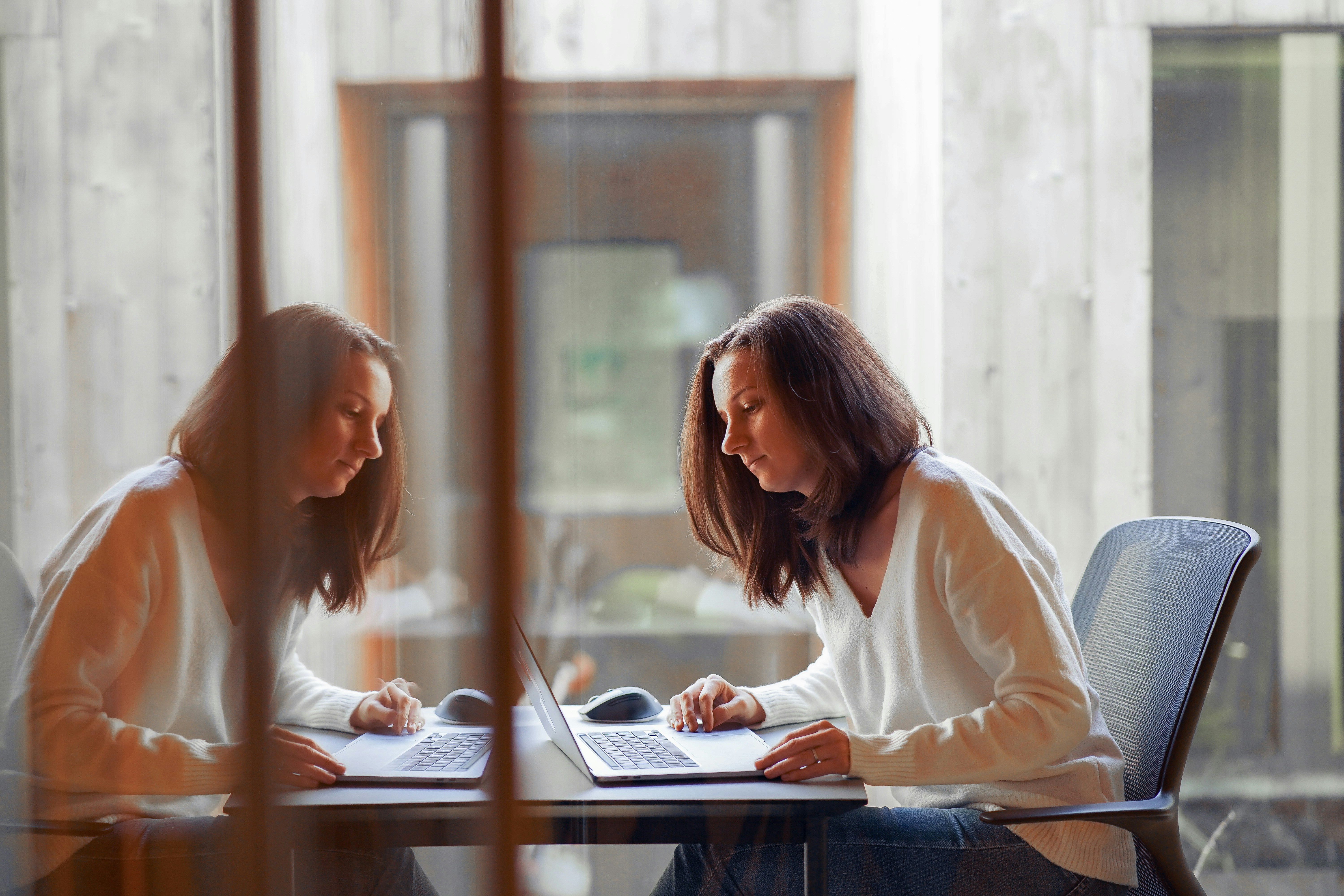 Femme travaillant sur ordinateur portable dans un espace calme dédié aux particuliers