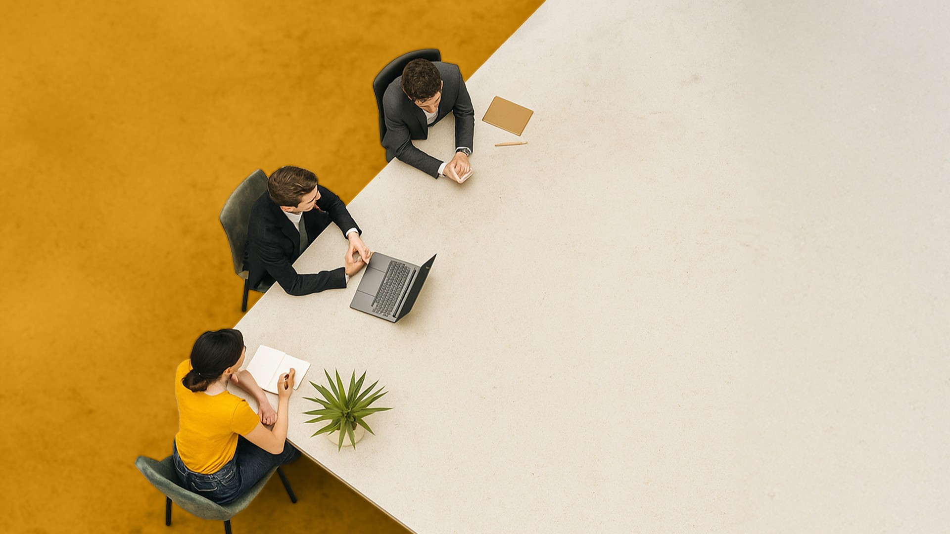 Trois professionnels en réunion autour d’une grande table claire, symbolisant la prise de contact et l’échange.