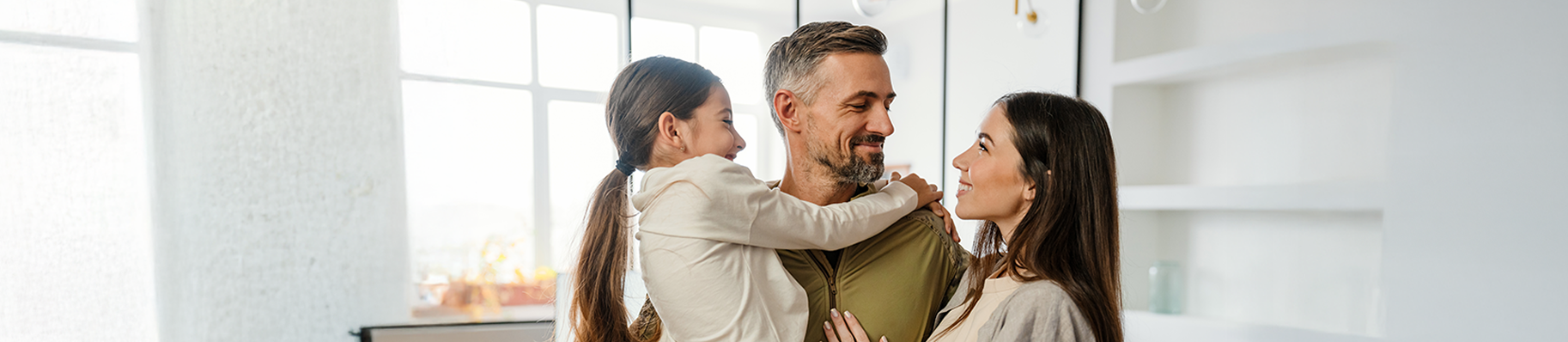 Famille souriante partageant un moment de complicité à la maison